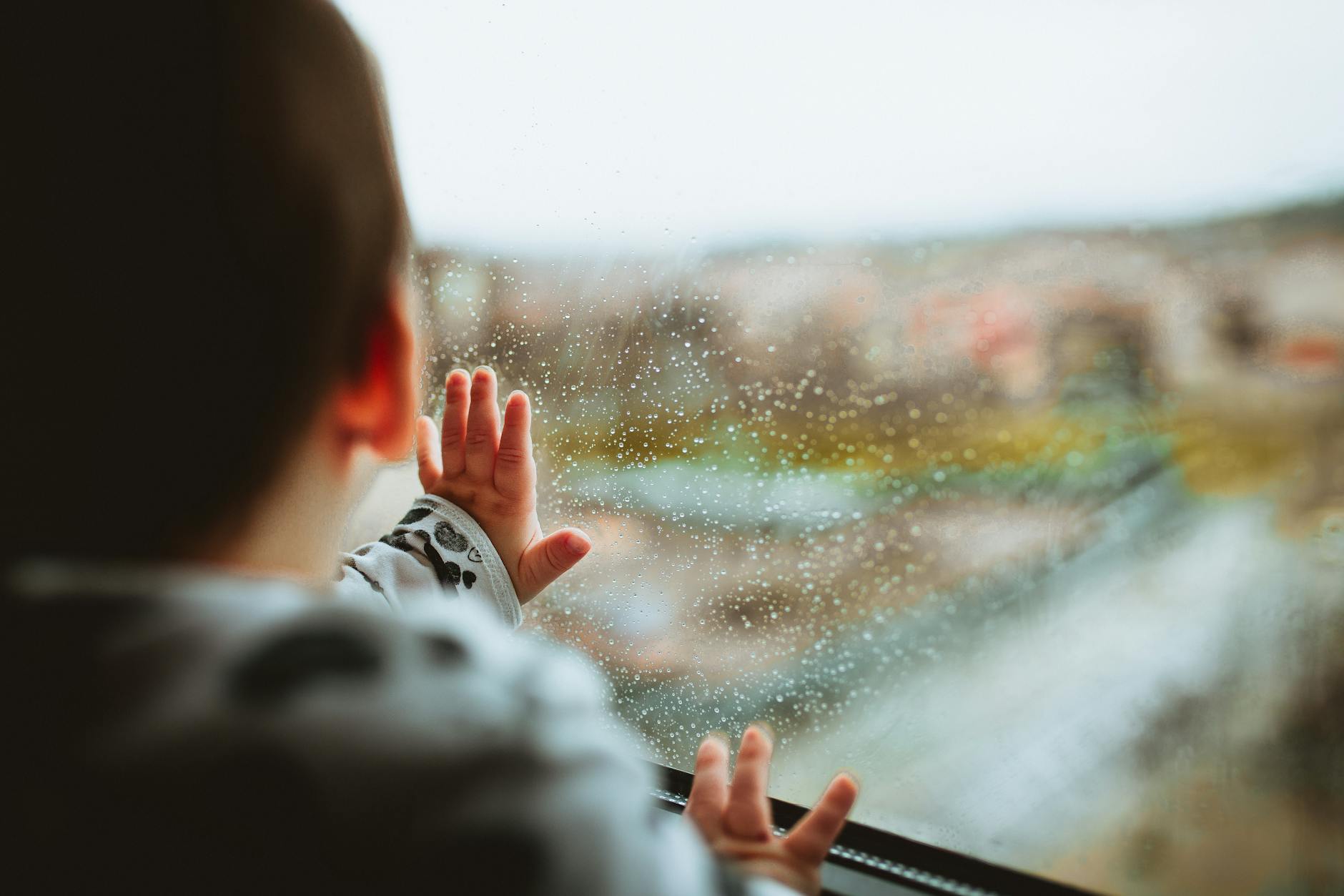 selective focus photography of a baby looking through the window