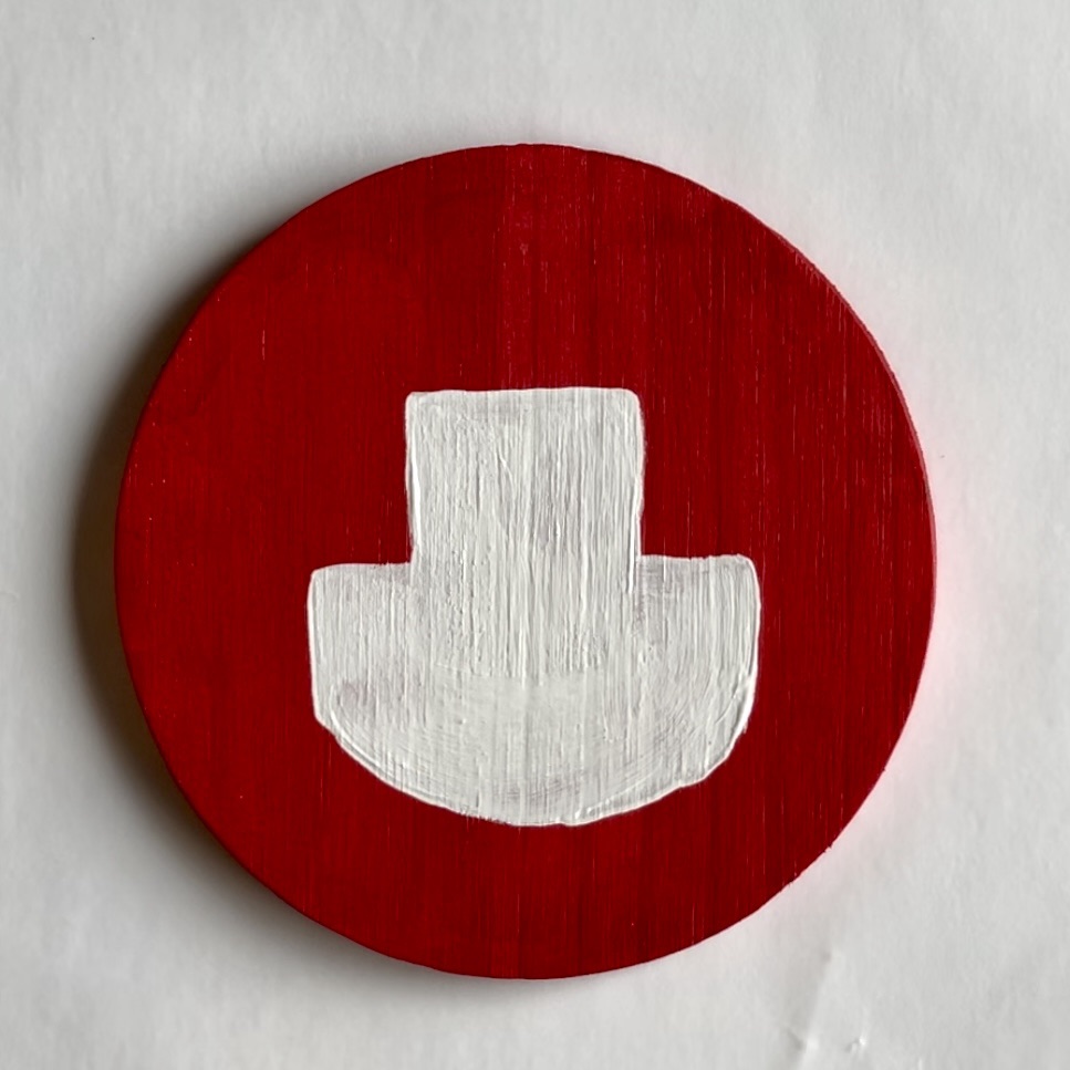 Red coaster with a white apron painted on it. 