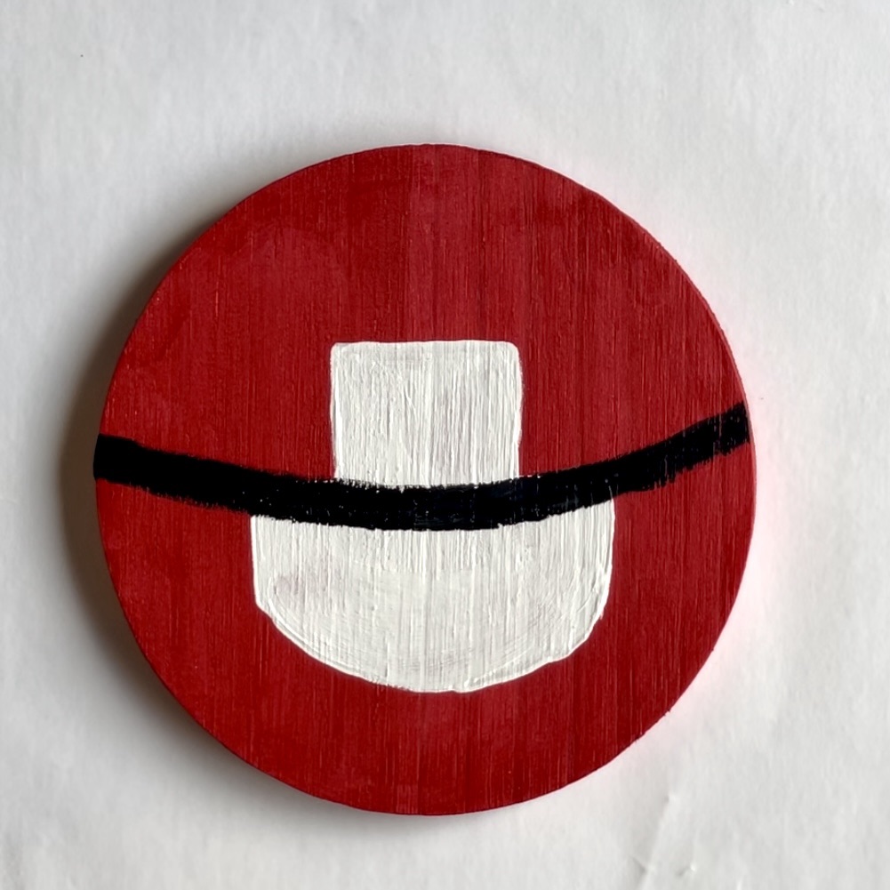Red coaster, with white apron and black belt painted on it. 