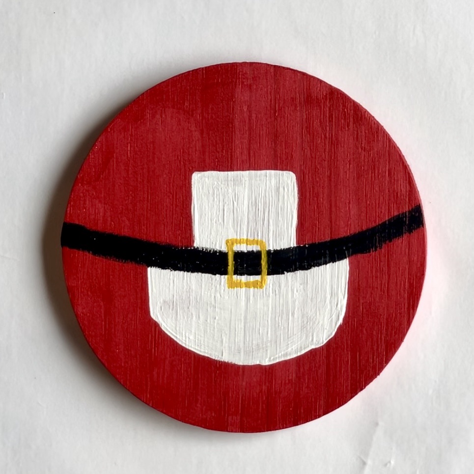 Finished Mrs. Claus Christmas Coaster. Red coaster with apron, belt and golden buckle.