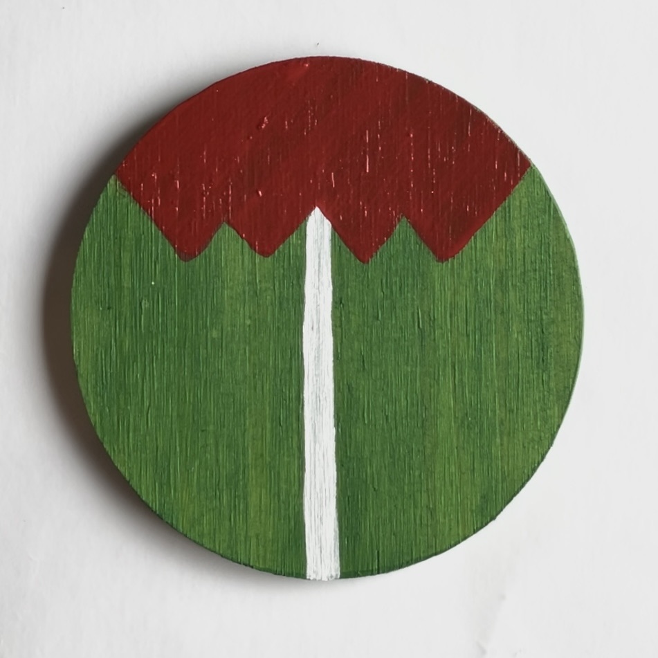 Green round coaster with white line and red shape with zig-zag line on the bottom. 