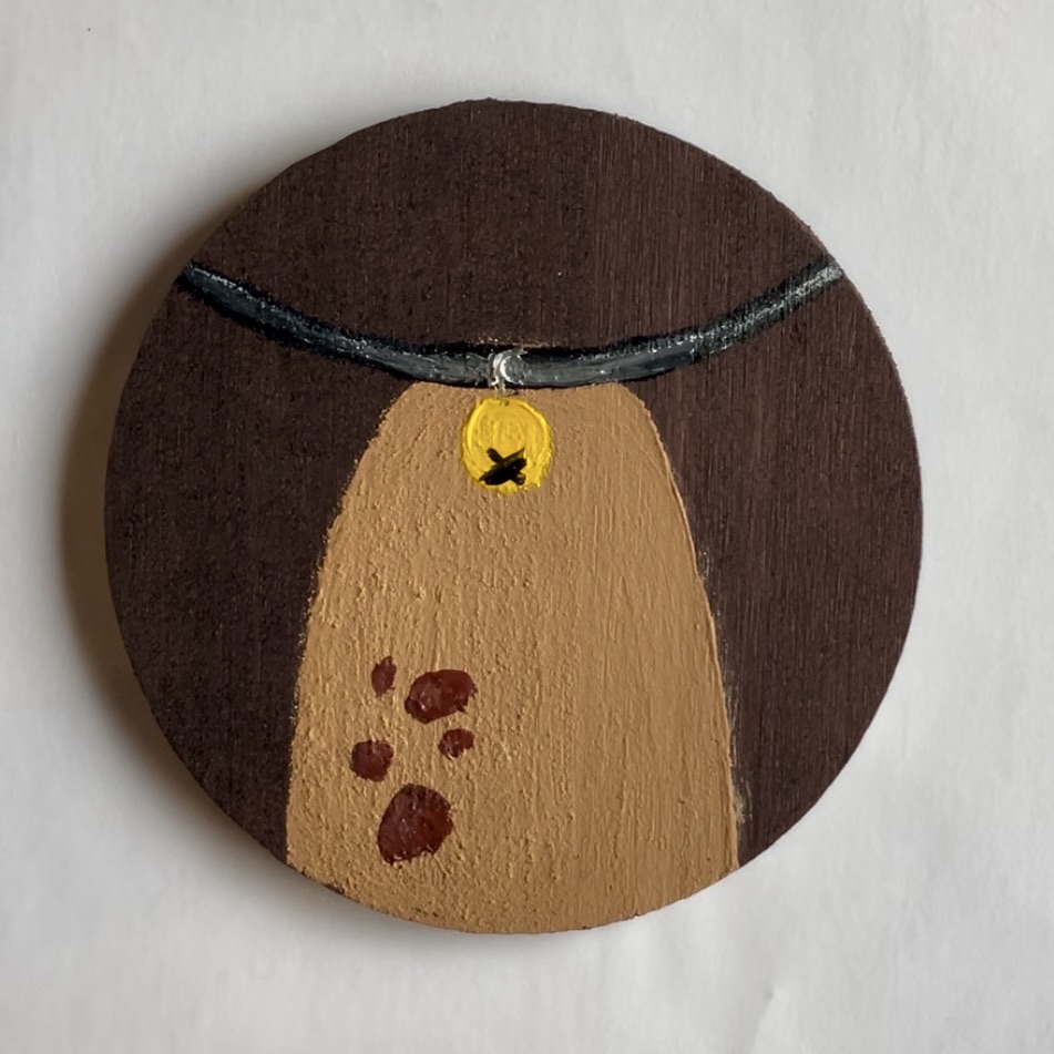 Finished Reindeer Tuft Coaster. With tan reindeer tuft and five brown spots, and a collar with a golden bell hanging on it. 