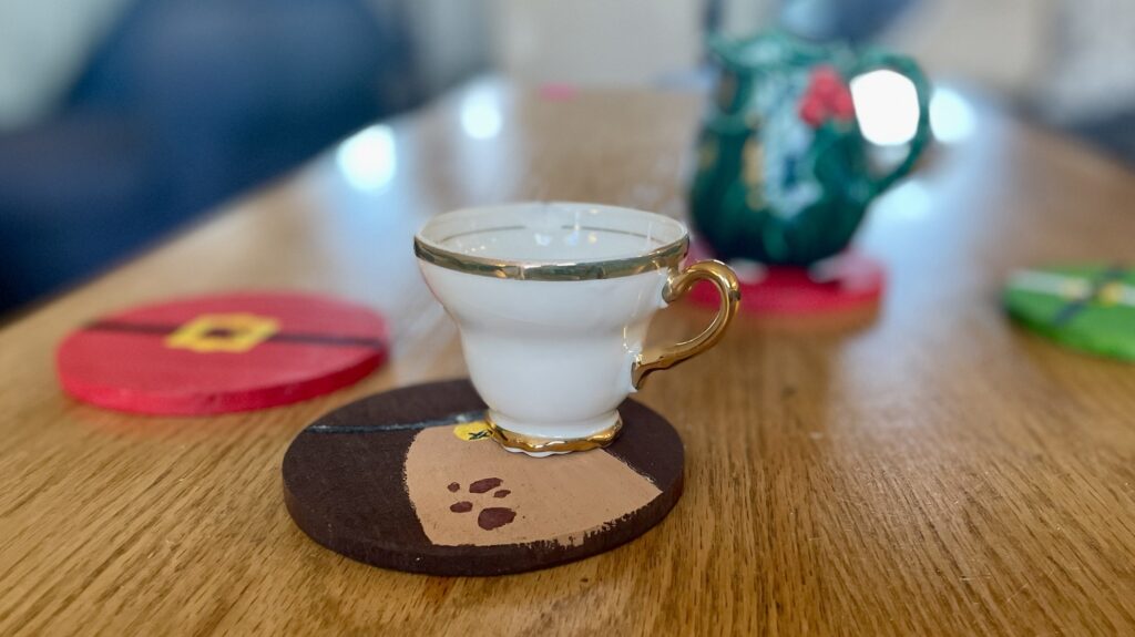Christmas coasters on the table with tea cups. 