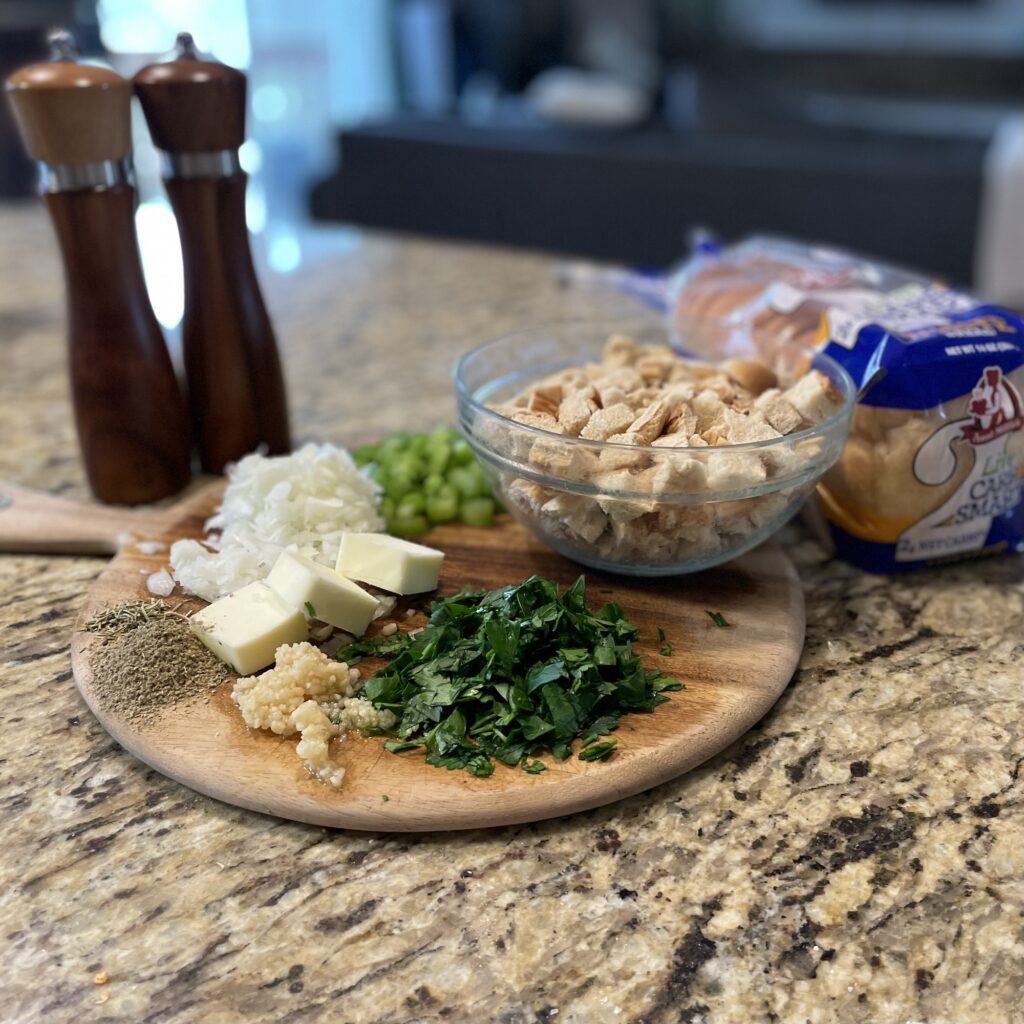 Photograph of ingredients for the low-carb stuffing recipe: bread cubes, butter, celery, onion, spices, parsley, salt, and pepper. 