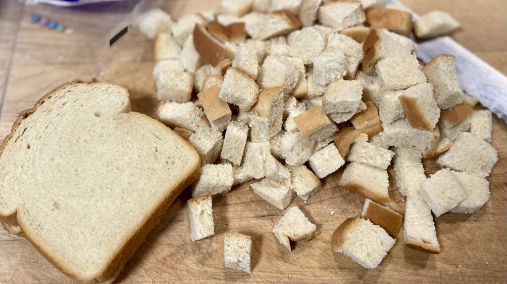 Cutting bread into cubes. 