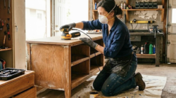 Woman refinishing a DIY project in a garage.